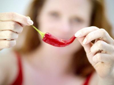 Foto Lámina fotográfica Woman Holding out a Red Chili Pepper de Maren Brinkmann, 61x46 in. foto 733397